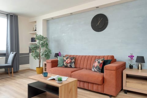 Bright and spacious studio apartment featuring a comfortable sofa, Smart TV, and contemporary interior design.