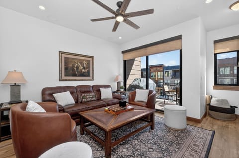Sink into rich leather seating while enjoying your mountain views through expansive windows in this sophisticated living space.
