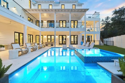 A stunning modern estate showcasing elegant architecture and a sparkling pool area perfect for your next luxurious retreat.