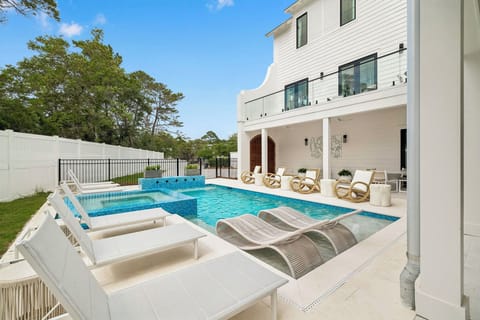 Your private backyard oasis awaits with a sparkling pool, luxurious hot tub, and plush lounge chairs beneath bright blue skies—perfect for soaking up the sun in style.