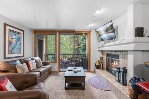 Living room with fireplace, smart tv, and walkout balcony