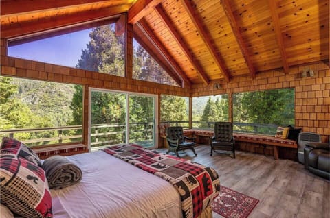 The master bedroom showcases a king bed wrapped in cozy textures and artisanal decor, where sunrise pours through the expansive glass, creating a serene and romantic atmosphere.