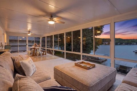 Bright sunroom surrounded by windows with stunning views of the lake, deck, cove, and passing boats.