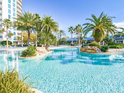 Sparkling resort-style pool w/ palm-lined islands, rock accents, and plenty of space to float and unwind.