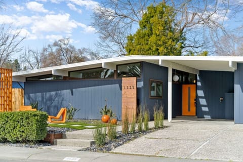 Lighted address, orange privacy wall and door invite you to our home.  Featuring one car in the car port, two car driveway.  Landscaping is modern and fun.
