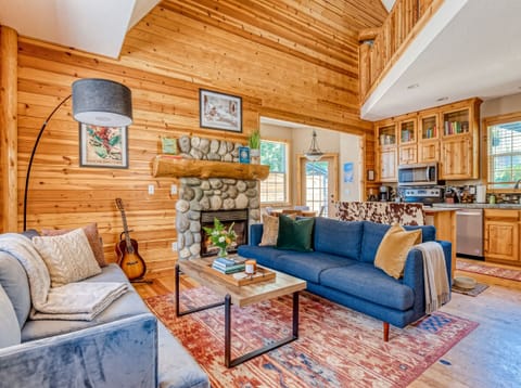 Living Room Oasis: Relax in style with rustic charm, a stunning stone fireplace, and vibrant decor!