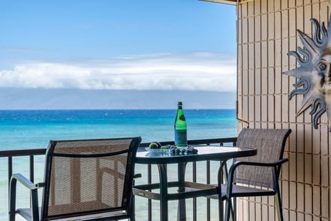 Relax on the lanai with bar seating and stunning ocean views just beyond the railing.