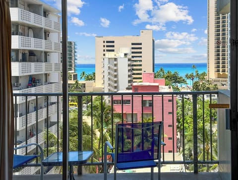 Balcony / Lanai - Step onto the private lanai/balcony at Waikiki Park Heights #808, settle into the outdoor seating, and enjoy warm island light with palm-lined city scenery and a refreshing partial Pacific Ocean view.
