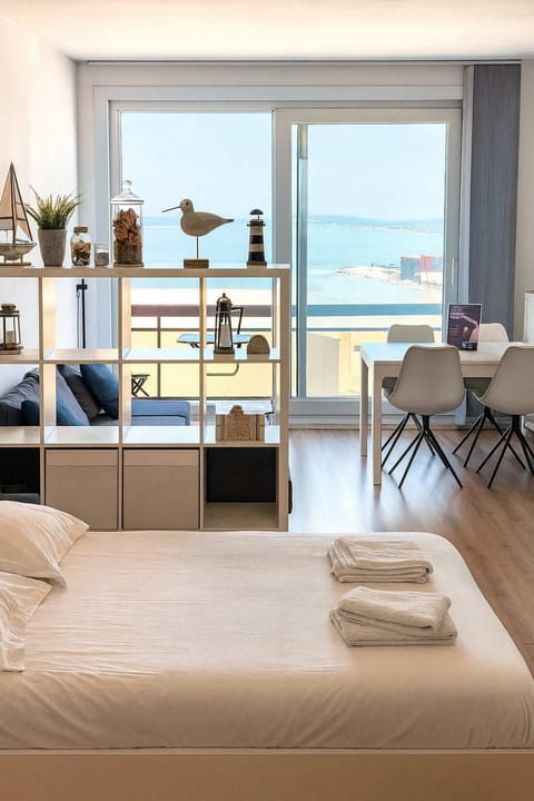 Sunny studio layout with bed and sea view. 🌊