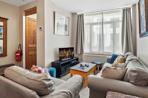 Cozy living room with natural light and comfortable seating around a rustic coffee table.