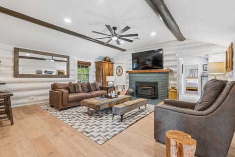Living room — whitewashed log walls and leather sofa