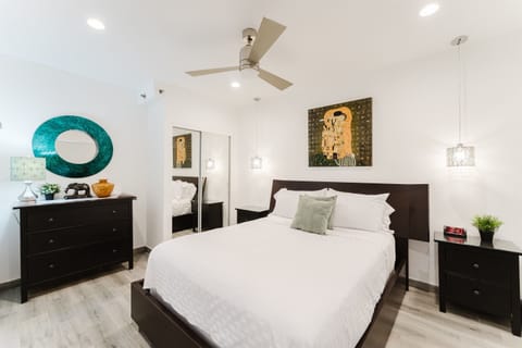 Rest easy in the spacious bedroom featuring a plush king-size bed, premium linens, and a calming atmosphere for a restful night's sleep.