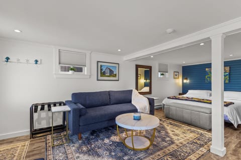 A cozy and thoughtfully designed living space featuring a comfortable seating area, inviting bedroom nook, and warm coastal-inspired touches—perfect for relaxing after a day of exploring.