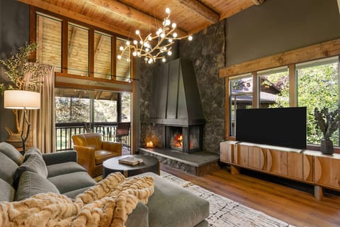 Gather beneath soaring timber ceilings beside the striking lava rock fireplace, with peaceful golf course views just beyond the deck.