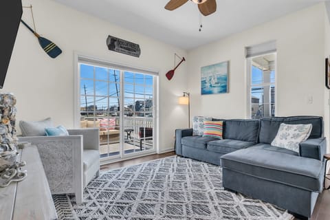 Bright coastal living room with large sectional and sun-filled windows