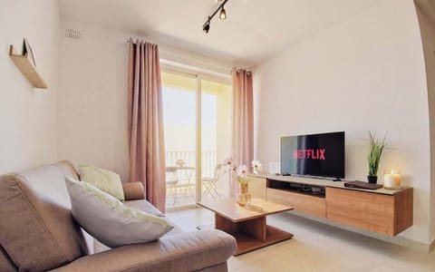 Comfortable living room area with smart TV, connected to a balcony overlooking the town.