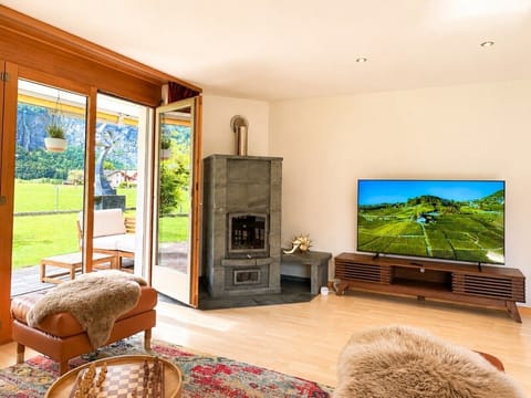 Ground-floor lounge with fireplace, terrace access and Swiss Alps views for cosy family evenings.