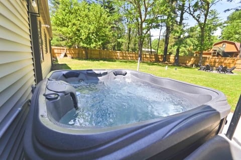 Soak up the sunshine and unwind in the bubbling hot tub, surrounded by a peaceful fenced yard and towering trees.