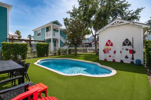 Private pool area with playful card-themed wall art and outdoor seating.