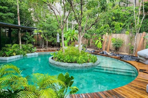 Escape to a hidden tropical paradise featuring a resort-style pool surrounded by lush greenery and serene nature.