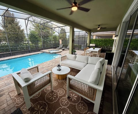 Covered outdoor living space with ceiling fans and pool cage