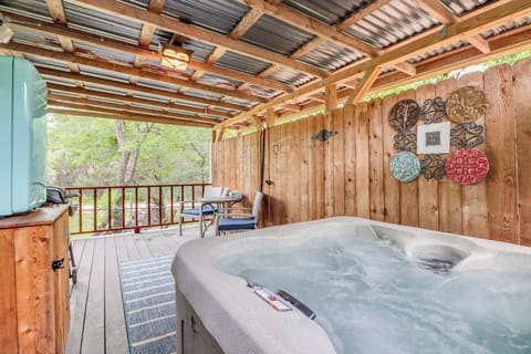 Slip into your private hot tub under a peaceful covered deck, where rustic wooden details and garden views create the ultimate relaxation retreat.