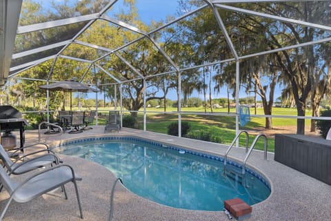 Dive into your private screened pool with stunning golf course views framed by majestic oaks draped in Spanish moss.