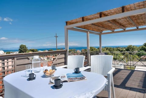 The rooftop terrace offers an inviting setting for outdoor dining and relaxing, with open views across Artemida and glimpses of the sea creating a memorable backdrop from morning through evening.