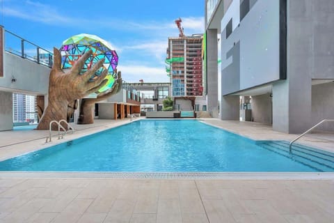 Sparkling rooftop pool surrounded by sleek modern architecture and vibrant city views. Lounge poolside, soak up the sun, and take in the striking urban backdrop. The perfect spot to relax and unwind above the bustling city below.