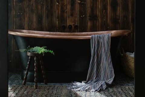 Hand-hammered copper against reclaimed dark wood and custom tile — dramatic, unexpected, and entirely unforgettable.