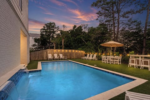 Private pool retreat with lounge seating, shaded dining, and an outdoor bar surrounded by trees.