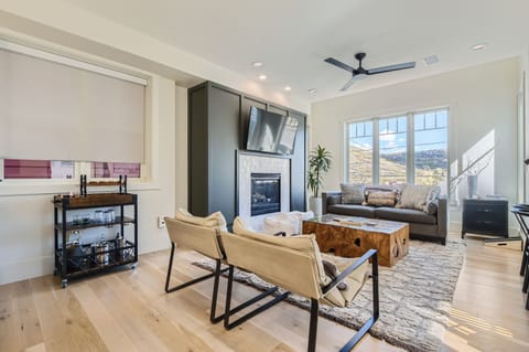 Bright and inviting living space with mountain views, a cozy fireplace, and stylish seating perfect for relaxing after a day of adventure.