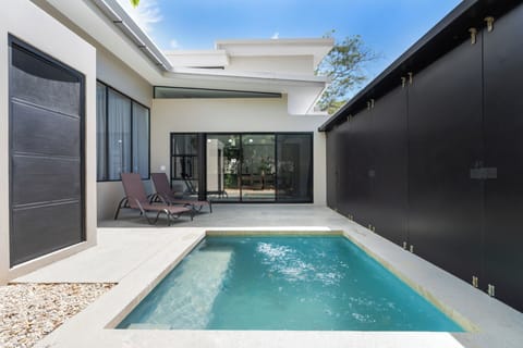 Step from the sun-drenched pool area with lounge chairs straight through the sliding glass doors into the villa. Experience seamless indoor-outdoor living at this premier Playa Langosta vacation rental near Tamarindo.