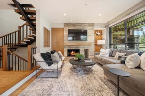 Living Room - Stone fireplace, vaulted ceilings, and a spiral staircase — stylish mountain-modern design throughout