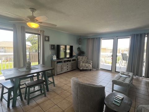 Settle into your bright, coastal-inspired living space where cool tile floors meet comfortable seating. Natural light pours in through glass doors opening to your private balcony with neighborhood views.