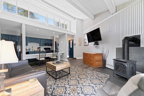 Relax in this bright, open living space with soaring cathedral ceilings, a cozy wood-burning stove, and modern farmhouse charm flowing into your fully-equipped kitchen.