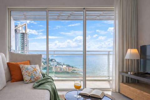 Sunlit living room with balcony, sweeping ocean and city skyline views . See the view in the 3D Tour: Please copy paste the LINK: https://my.matterport.com/show/?m=tN6tEF3sYZP