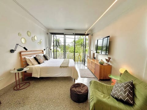 【Master Bedroom】King size bed with hotel grade bedding and ample light. Balcony with Bangkok skyline view. Breezy sliding doors for morning bird songs. Escape Bangkok’s city noise in a designer house oasis. TV with a soundbar complete the  room.