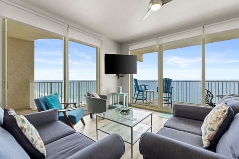 The living room offers a bright and welcoming space with two large sliding glass doors that open directly onto the balcony.