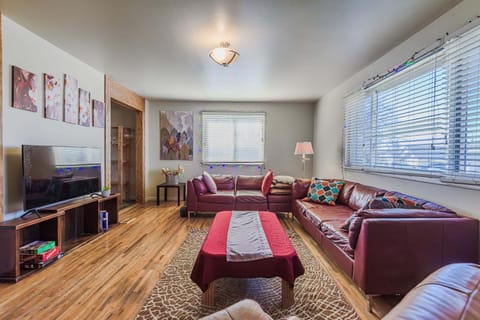 Spacious living room with plush sectional, smart TV, and hardwood floors.