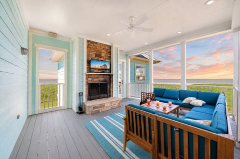 Covered outdoor lounge area featuring comfortable seating, coastal décor, and beautiful Gulf views. Perfect for relaxing while enjoying the scenery.