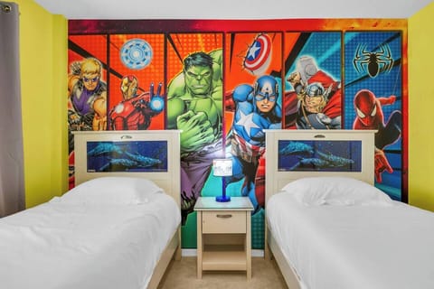 Marvel-themed bedroom w/ vibrant wall art & two beds — a fun retreat for young guests.