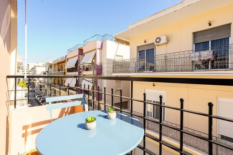 Sunny balcony with outdoor dining and neighborhood views