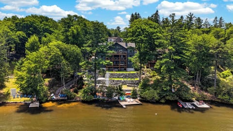 Aerial view of the full lakefront property, with decks, outdoor gathering areas, and direct access to the water.