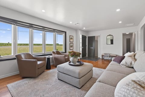 Bright living room with panoramic windows, plush seating, and open views