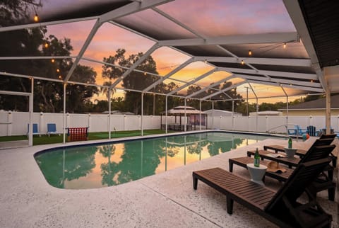 Splash into golden hour — the screened pool glows as the sun dips below the horizon.
