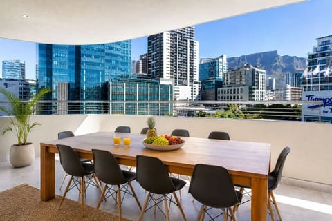 Spacious covered terrace with outdoor dining, offering a relaxed setting for alfresco meals while enjoying city skyline and mountain views.