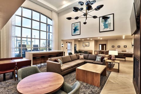 The Great Room serves complimentary hot breakfast Mon–Fri and doubles as the evening social space Mon–Wed