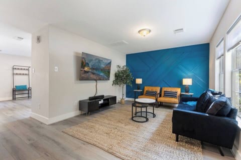 Enjoy the feature wall with leather chairs, velvet sofa, and chenille throw 