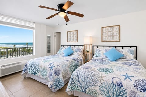 Bright bedroom with 2 full-size beds and ocean views from the 5th floor.
